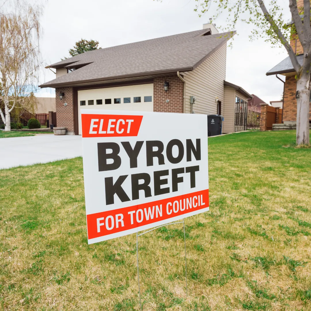 Printed coroplast election sign in front of a house