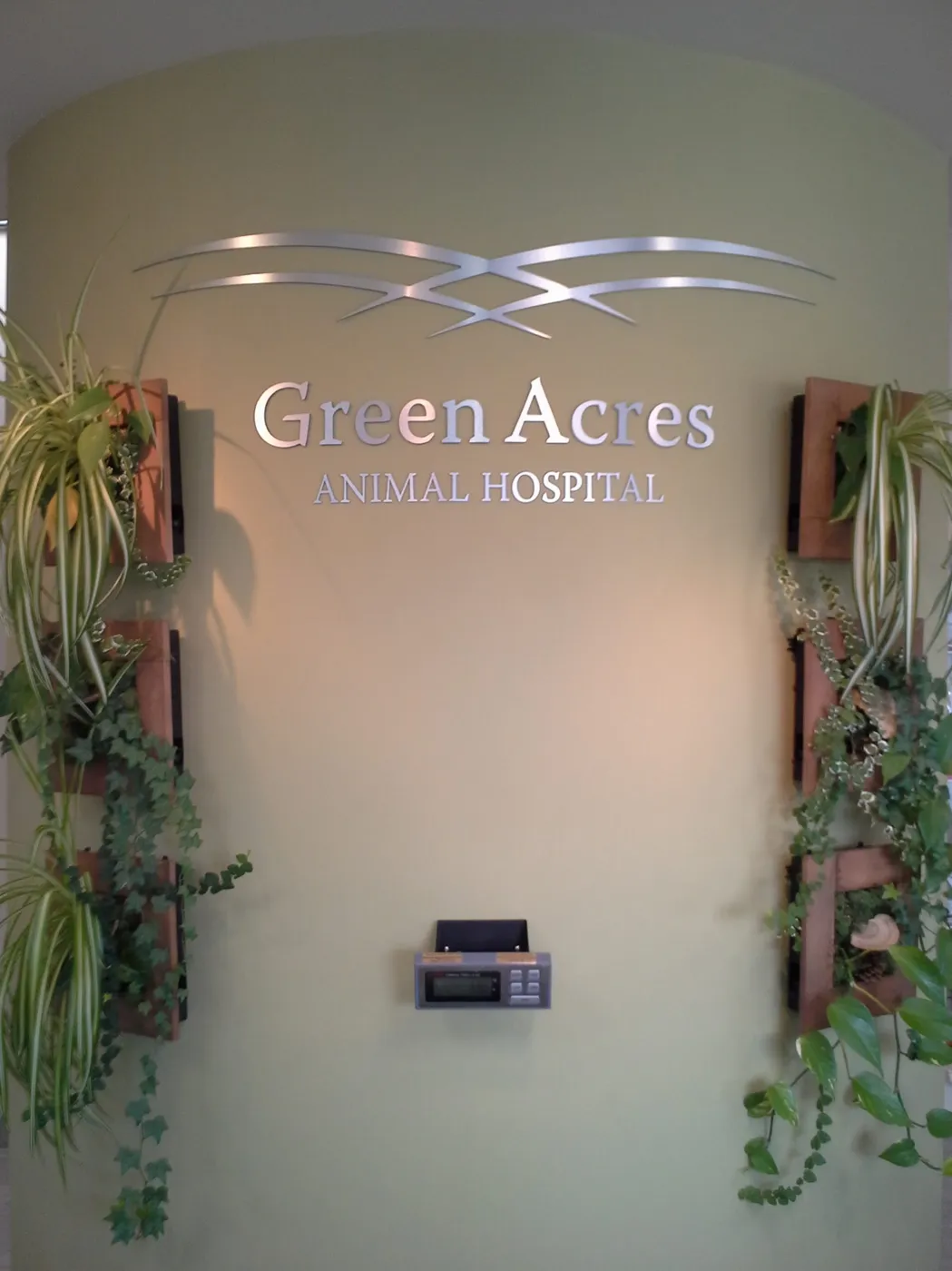 Brushed aluminum composite sign on a curved reception wall