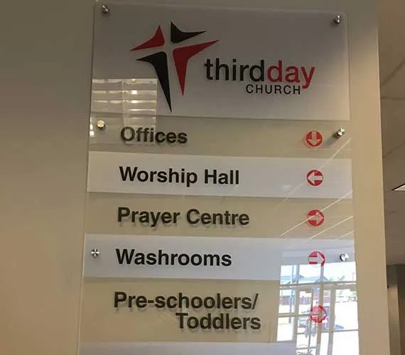 Acrylic wayfinding directory with room names and arrows